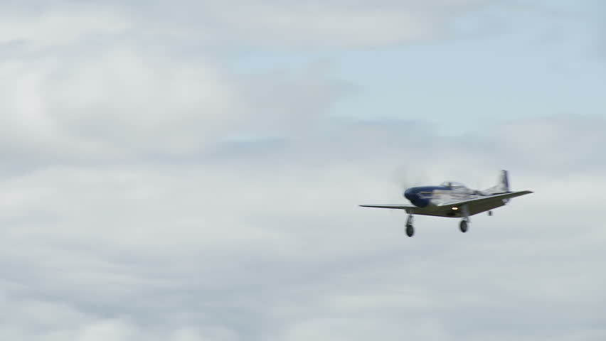 Two clips of a historic USAF P-51 Mustang, in flight and landing on airfield.