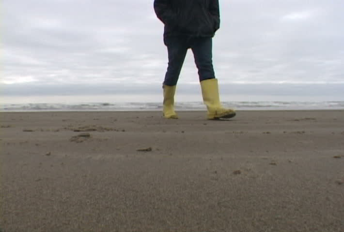 Woman at Haystack Rock in Cannon Beach, Oregon wearing yellow boots in clip