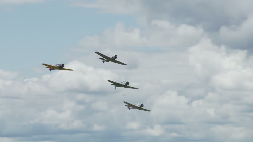 Four USAF T-6 Texans, training aircraft from WWII, flying in formation.
