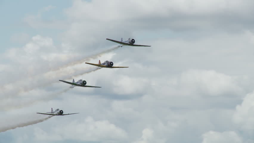 Four USAF T-6 Texans, training aircraft from WWII, in flight, performing stunts