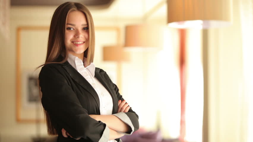 Business woman standing in a cafe and smiling
