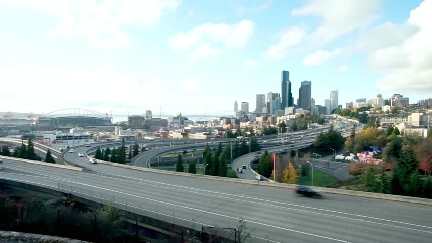 Seattle skyline with highway and bridge on a sunny day with some clouds