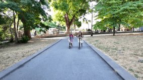 Two girls with backpacks, riding scooter in the park. Happy kids enjoying outdoor fun, friendship and an active childhood lifestyle. - Powered by Shutterstock - Get 15% off with code: PIKWIZARD15