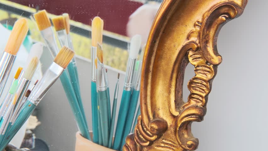 Antique artwork detail, restorer working with brush, gold frame cleaning, closeup historical artifact before sale, art object ready for expert evaluation and auction