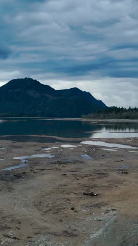Peaceful Landscape of Lake and Forest Mountains Reflecting Under a Dramatic Cloudy Sky in Canada