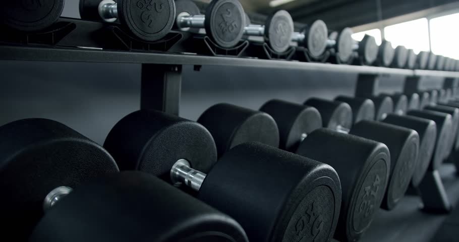 Close-up view of neatly arranged dumbbells on a rack in a modern gym, highlighting the fitness equipment. Rows of Dumbbells in Modern Gym, Fitness Equipment Close-up