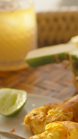Hand lifts pineapple fried rice with fork above tropical tray with shrimp lime salad and cold drinks at sunset, close up, warm lighting, low angle, Thai Cuisine Concept.