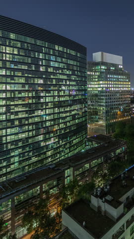 Aerial night timelapse of Brussels urban landscape blending office skyscrapers with residential areas. Green park lawns, historic rooftops and modern architecture create a diverse cityscape in Belgium