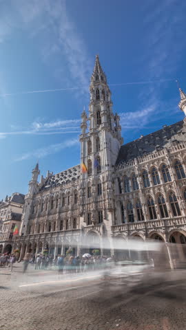 Timelapse hyperlapse of Town Hall (Hotel de Ville) on the Grand Place in Brussels, Belgium. Looking up at the Gothic tower and facade. A UNESCO World Heritage Site and major tourist destination