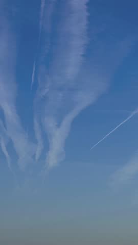 Timelapse of airplane contrail against blue sky with white cloud. Jet plane condensation trail. Clouds lines made of aircraft