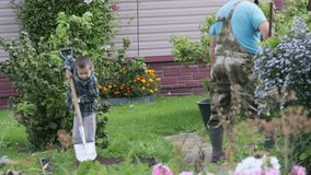 Grandfather and grandson gardening - Boy digging with shovel - A little boy helps his grandpa in the backyard, working hard to dig soil. A moment of family bonding and teamwork in the garden - Powered by Shutterstock - Get 15% off with code: PIKWIZARD15