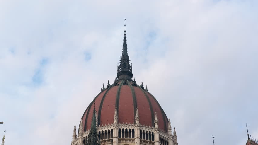 Hungarian parliament building dome detail showing cloudy sky. Ornamental details highlighting hungarian parliament building dome, rising against dramatically cloudy sky
