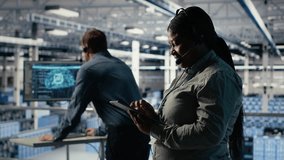 Data center system administrator uses AI on tablet to help customers resolve website hosting problems. African american woman in server farm helps users keep online services running smoothly, camera B - Powered by Shutterstock - Get 15% off with code: PIKWIZARD15