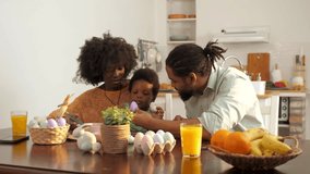 Family members collaborating while painting colorful easter eggs, sharing laughter and creativity in bright kitchen setting, displaying warm bonding moments during festive season - Powered by Shutterstock - Get 15% off with code: PIKWIZARD15