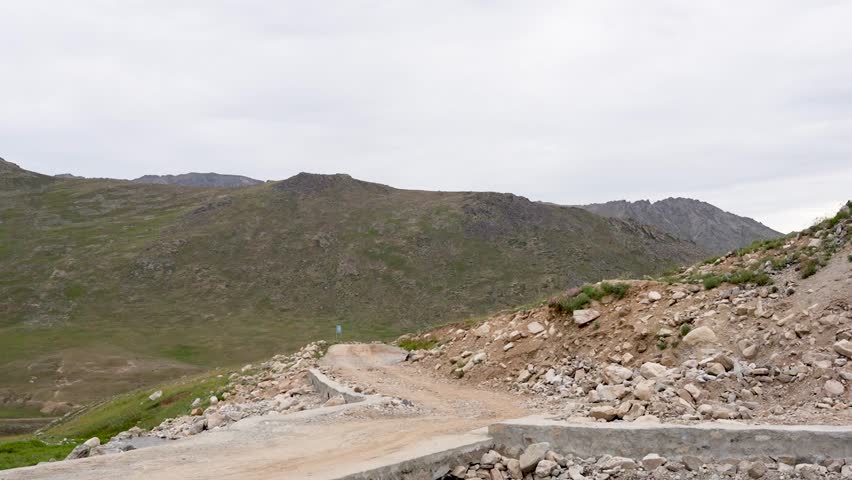 Winding dirt road through rocky hills toward Deosai National Park in Astore. Gilgit-Baltistan, Pakistan