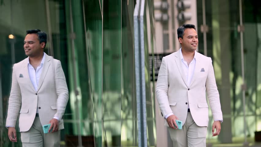Professional Indian businessman wearing crisp white suit walking through Melbourne