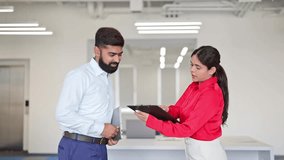 Indian businessman and successful businesswoman engaged in a focused business meeting inside a modern office. Dressed in formal attire, they are discussing important strategies with intent. - Powered by Shutterstock - Get 15% off with code: PIKWIZARD15