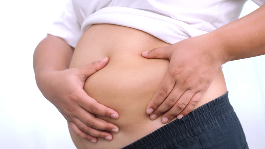 Asian woman use hand to squeeze fat belly big size overweight and obesity.