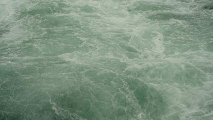 Intense turquoise rapids swirl and foam in the powerful currents above Niagara Falls.