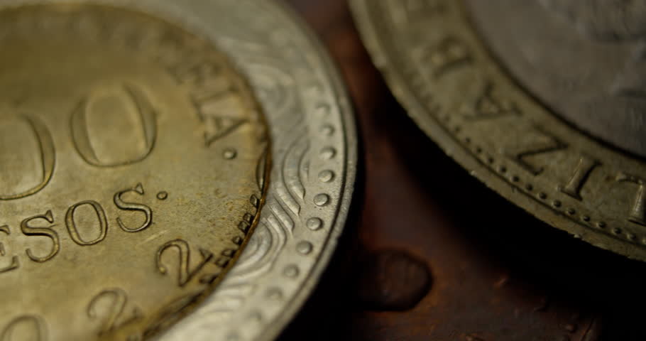 Close-up macro view of a Mexican 500 pesos coin, showing detailed engravings, texture, and metallic shine under soft lighting