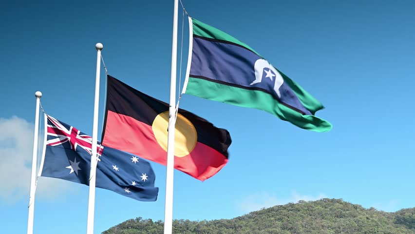 The Australian, Aboriginal, and Torres Strait Islander flags flying side by side in the wind—symbolizing unity, identity, and respect across cultures in Australia's diverse national landscape.