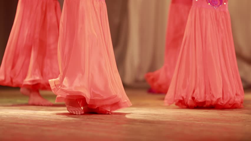 Young woman belly dancer in a oriental costume dancing on stage