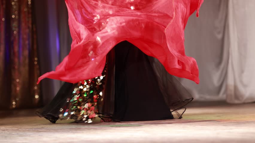 Young woman belly dancer in a oriental costume dancing on stage