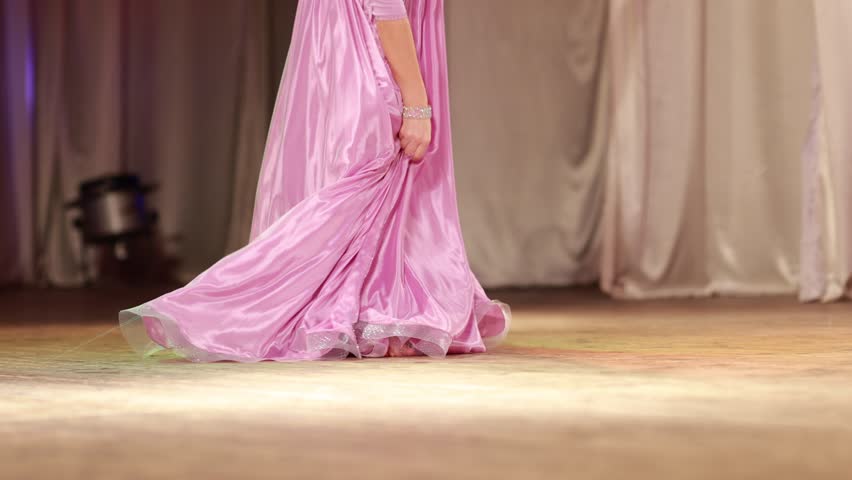 Young woman belly dancer in a oriental costume dancing on stage