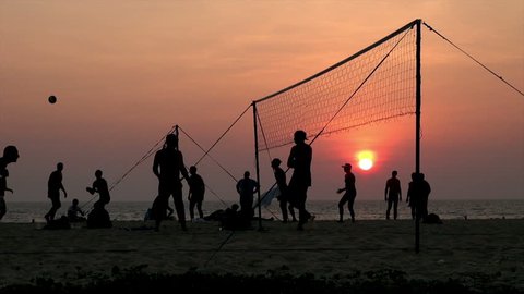 bunch of people play beach volleyball at Karon Beach, Thailand / people enjoying beach volley at sunset 