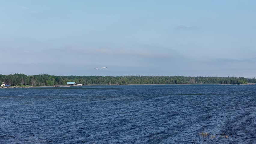 Aerial drone view over deep blue waters with a distant shoreline and forested horizon in Michigan’s Upper Peninsula.