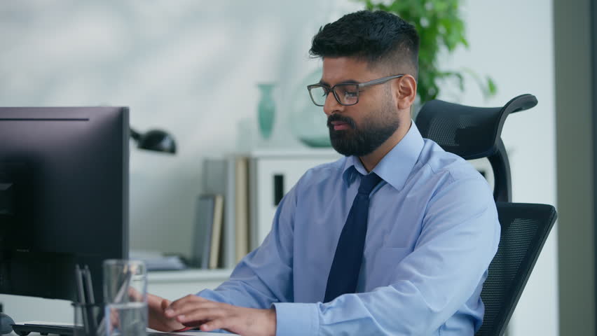 Muslim man Arabian business male worker Indian productive businessman guy working with computer looking at camera smiling happy positive manager online good work at table smile satisfied portrait