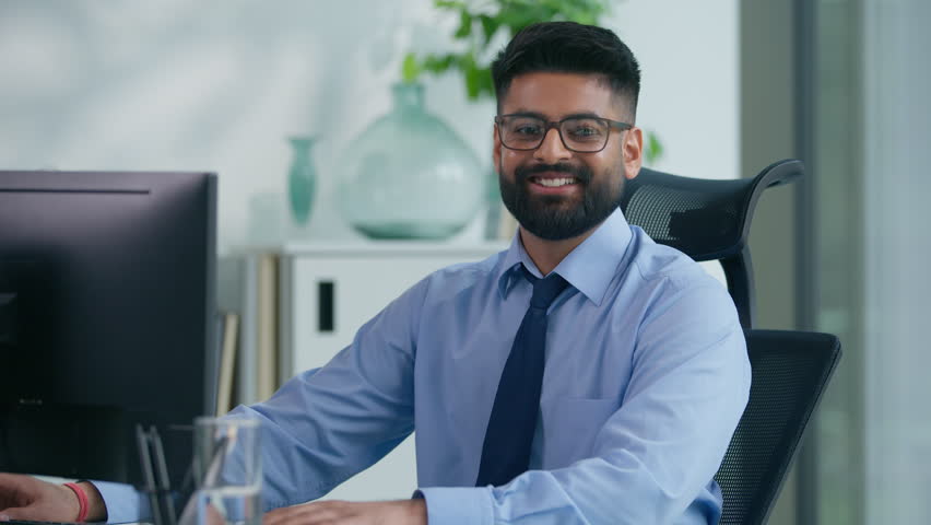 Muslim man Arabian business male worker Indian productive businessman guy working with computer looking at camera smiling happy positive manager online good work at table smile satisfied portrait