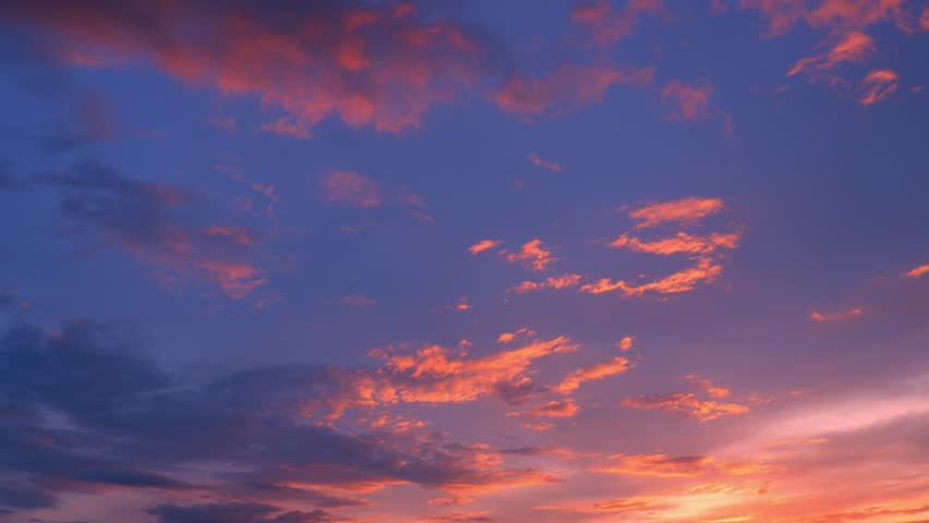 A vivid sunset timelapse captures the sky in a dynamic display of deep blues and fiery orange clouds, shifting and glowing as daylight fades, showcasing nature’s ever-changing and mesmerizing beauty.
