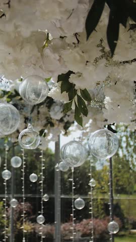Vertical video. decorated tables in a restaurant at a wedding or event. Tent decor, decorated tables, decorated banquet hall. Beautiful flower arrangement above the table.