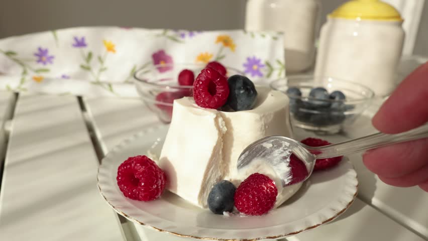 Woman and ricotta cheese dessert with berries. Table setting. Raspberries and blueberries. Healthy eating and vitamins. Environmentally friendly products. Mediterranean diet.