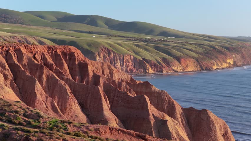Aerial pan of Sellicks Beach red cliffs with golden hour light near Adelaide, South Australia