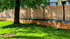 Wooden Plank Fence On A Brick Stone Base In The Yard. Static Shot - Powered by Shutterstock - Get 15% off with code: PIKWIZARD15