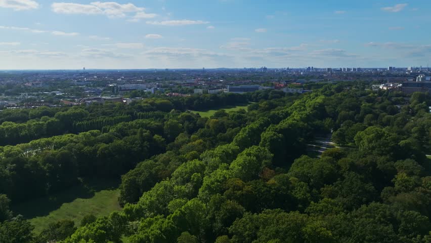 Aerial drone view of Treptower Park in Berlin, Germany – a vast riverside green space featuring tree-lined paths, the Soviet War Memorial, and scenic landscapes along the Spree River from above.