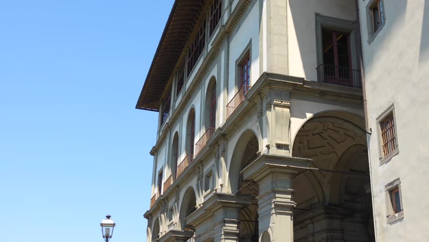 Uffizi Gallery arches and columns, street lamp, Florence Italy, blue sky
