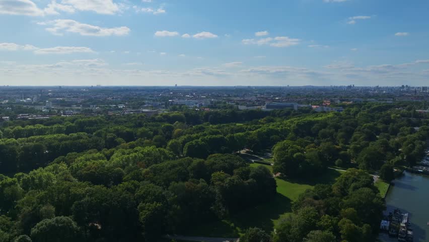Aerial drone view of Treptower Park in Berlin, Germany – a vast riverside green space featuring tree-lined paths, the Soviet War Memorial, and scenic landscapes along the Spree River from above.