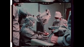 1979 USA. A precise operation in a sterile field— surgeons in full attire work with sealed instruments under strict contamination control, focused teamwork, and steady hands. 4K Overscan archival film - Powered by Shutterstock - Get 15% off with code: PIKWIZARD15