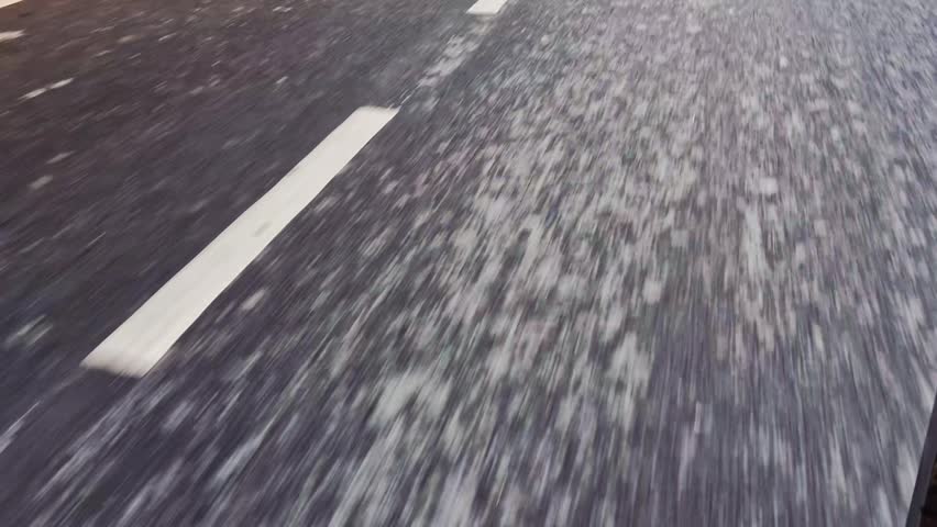 Dynamic view of a road with white stripes passing by, capturing motion on asphalt, road markings, and the essence of travel and driving perspective