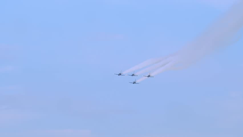 Four planes fly in a diamond formation against the blue sky during the airshow.
