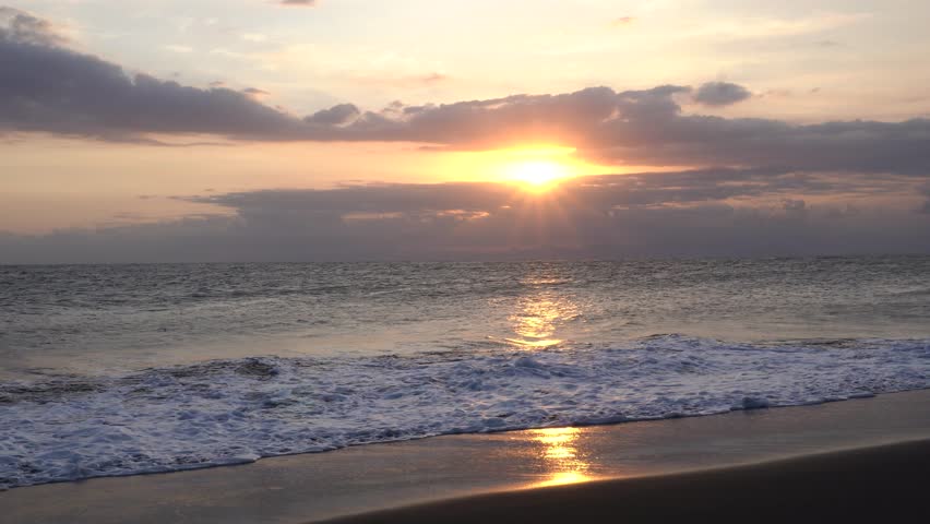 Ocean waves crashing on beach, golding time sunset
