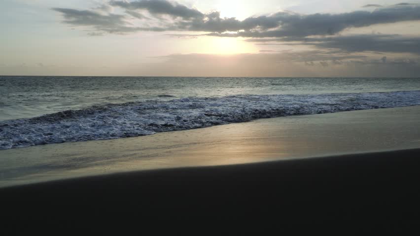 Ocean waves crashing on beach, golding time sunset