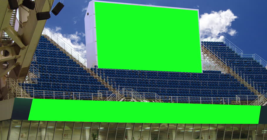 Stadium scoreboard against the backdrop of clouds and blue sky.