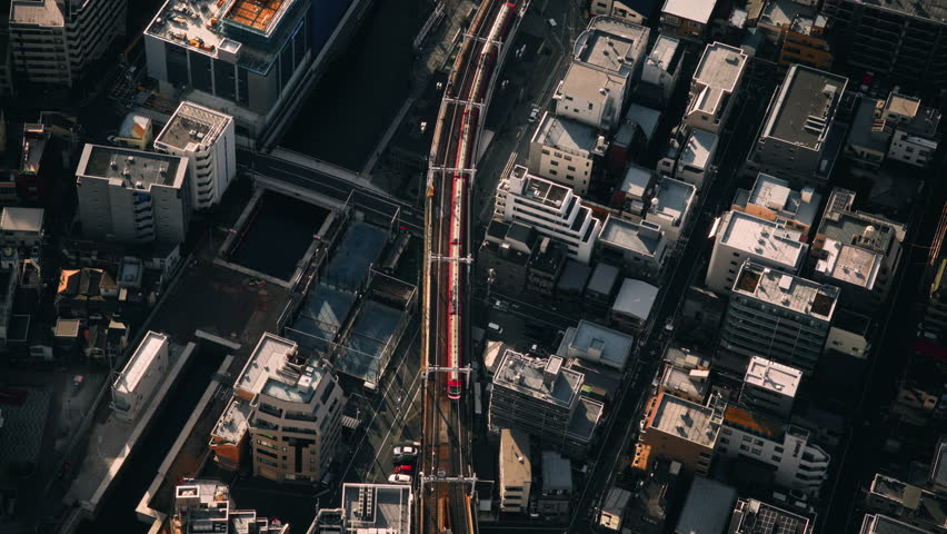 Aerial View of Red Train Passing Through Tokyo Cityscape