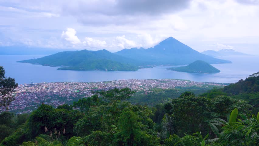 Exotic islands in the tropical Spice Islands (Moluccas). Indonesia. Indian Ocean. Cruise sea voyage place, seaport town. Rain mountain forest in the foreground