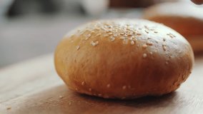 Gourmet burger bun with sesame seeds closeup, chef preparing delicious food for culinary experience, fast motion cooking preparation, mouthwatering meal assembly - Powered by Shutterstock - Get 15% off with code: PIKWIZARD15