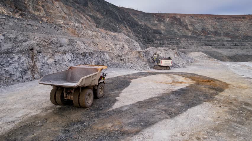 Aerial View Excavator and Dump Truck on Open Pit Mine, process gold, copper and iron mining.